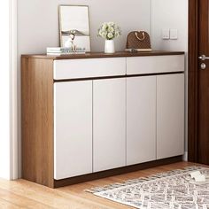 a white cabinet sitting on top of a hard wood floor next to a wooden door