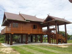 a large wooden house sitting on top of a lush green field