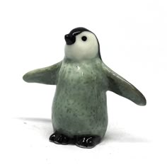 a ceramic figurine of a penguin with one eye open