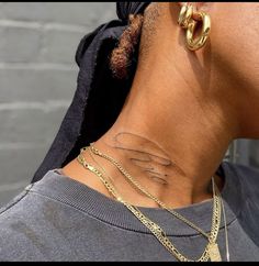 a woman with a gold chain around her neck has a tattoo on her lower back