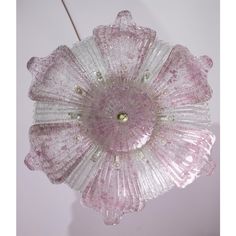 a pink flower shaped light hanging from a ceiling