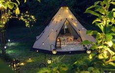 a tent is lit up with fairy lights