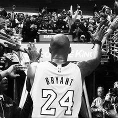 a black and white photo of a basketball player holding his hands up in the air