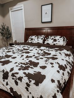 a bed with brown and white cow print comforter