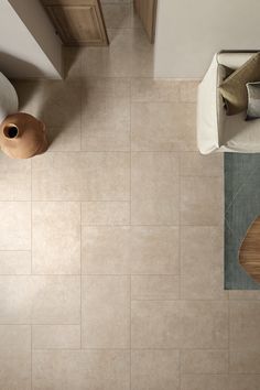 an overhead view of a living room and kitchen area with beige tile flooring on the walls