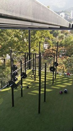 an outdoor gym with several balls on the grass