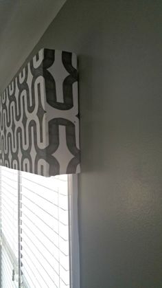 the blinds are closed in front of the window with black and white patterns on them