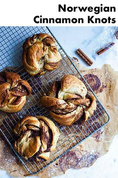 four cinnamon rolls on a cooling rack with cinnamon sticks in the background and text overlay that reads, norwegian cinnamon knots