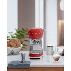 a red coffee maker sitting on top of a counter