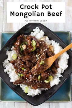 a black plate topped with beef and rice on top of a blue plate next to a wooden