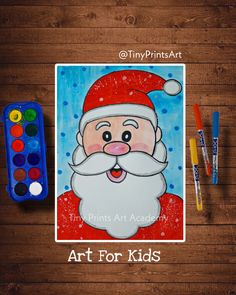 an art for kids poster with santa clause on it next to markers and paintbrushes