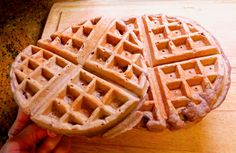 two waffles sitting on top of a wooden cutting board next to each other