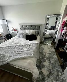 a bedroom with a bed, mirror and closet