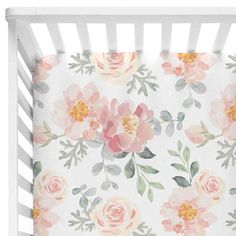 a white crib with pink flowers and green leaves on the bottom, in front of a white background