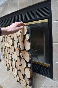 a person is placing wood on the side of a fireplace