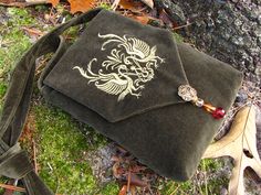 a purse with a dragon on it laying on the ground