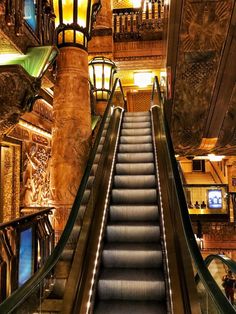 an escalator in a building with lights on