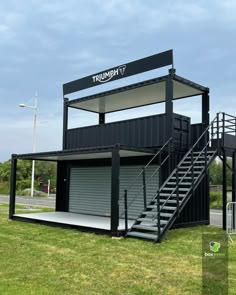 a large shipping container with stairs leading up to it's second floor and garage