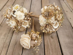 three bouquets of flowers sitting on top of a wooden table