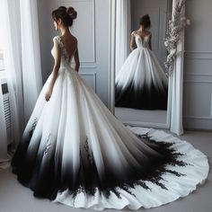 a woman in a black and white wedding dress looking into a mirror