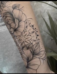 a black and white flower tattoo on the arm