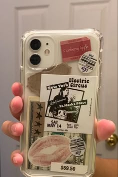 someone holding up their phone case with some stickers on it