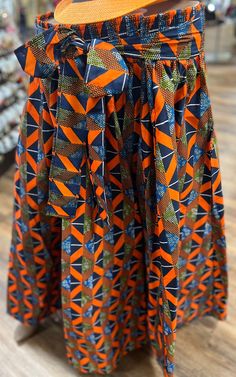 This  is a beautiful ethnic skirt that has an elastic waist band that allows it to fit multiple sizes. A waist tie belt and pockets on the sides for comfort and play. The Length 28 inches long.  Colors Orange , & Blue. Why not add this to your collection of wearable art today, Please don't delay. African Skirt, Broomstick Skirt, Western Skirts, African Skirts, Elastic Skirt, Orange Skirt, Elastic Waist Skirt, Dance Skirt, Colors Orange