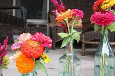 three vases filled with colorful flowers on top of a table