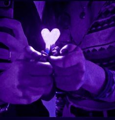 a person holding a smart phone in their hands with a heart on it's screen