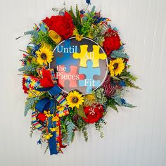 a wreath made out of puzzle pieces with flowers and ribbons around it that says until all the pieces fit