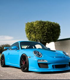 a blue sports car parked in front of a building