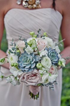 a bridal holding a bouquet of flowers and succulents