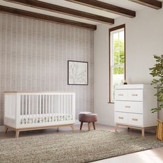 a baby's room with a crib, dresser and potted plant