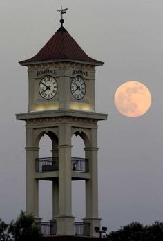 a clock tower with a full moon in the background