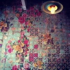 an overhead view of a tiled floor with flowers on it and a candle in the middle