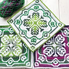 three crocheted placemats with green, purple and white designs on them