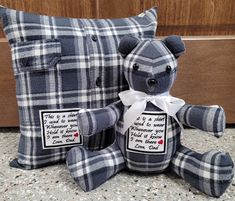 a blue plaid teddy bear sitting next to a pillow with a poem written on it