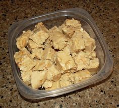 a plastic container filled with pieces of food on top of a granite countertop next to a brown tile floor