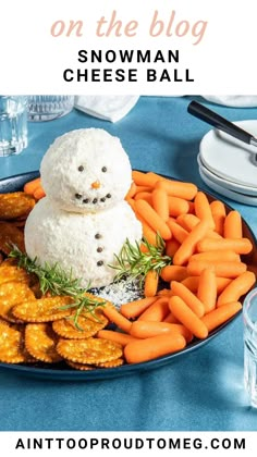 a plate with carrots, crackers and a snowman on it that has cheese balls in the middle