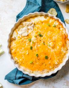 an image of a baked dish with cheese and vegetables in it on a cloth next to other dishes