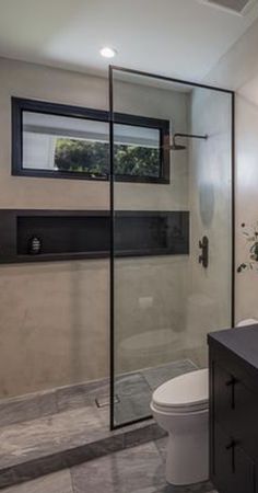 a bathroom with a sink, toilet and shower stall in the middle of the room