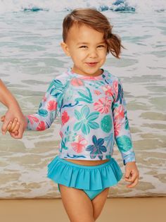 It's safety first with UPF 40+ sun protection in our rash guard swim set. Fashion comes in a close second, featuring a vibrant undersea garden graphic on the long raglan sleeve top--and a deep sea turquoise solid for the diaper-friendly ruffled bottoms with an interior lining for extra protection. Poly/spandex blend for the right bit of stretch. We recommend hand washing and laying flat to dry to extend the life of this set.  Matching family styles are available in our Sibling Shop. Garden Graphic, Raglan Sleeve Top, Baby Swimming, Safety First, Swim Sets, Tea Collection, Rash Guard, Deep Sea, Hip Length