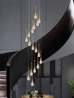 a modern chandelier hanging from the ceiling in a living room next to a spiral staircase