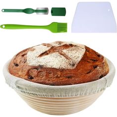 a loaf of bread sitting on top of a bowl next to plastic utensils