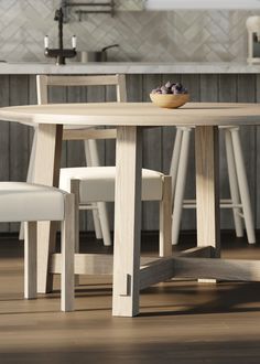 a wooden table with two white chairs and a bowl of fruit on top of it