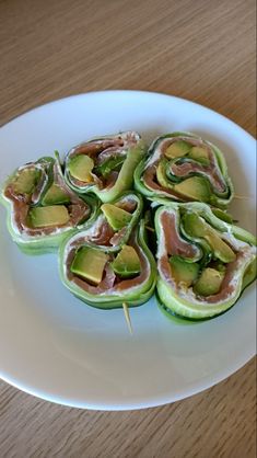 there are cucumbers on the plate with toothpicks in them and some sort of appetizer