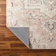 the rug is laying on top of the wooden floor next to it's edge