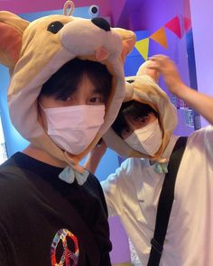 two people wearing animal hats and masks