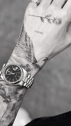 black and white photograph of a man's arm with tattoos on both sides of his wrist