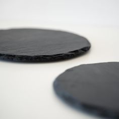 two black plates sitting on top of a white table